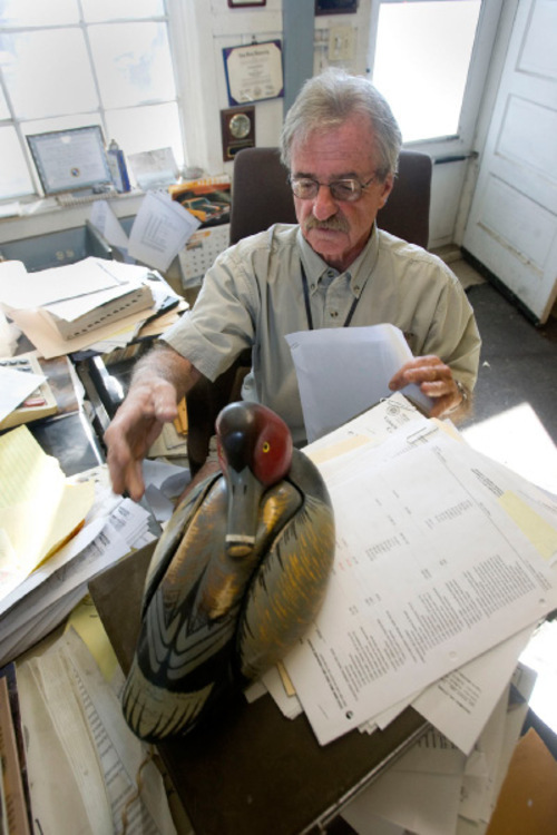 Al Hartmann  |  The Salt Lake Tribune&#xA;Val Bachman,  manager of Ogden Bay Waterfoul Managment area, has been there his entire career.  Here, Bachman, works away at records in his office, which was built by the CCC in the 1930s.  The wooden duck decoy in foreground is actually a telephone.